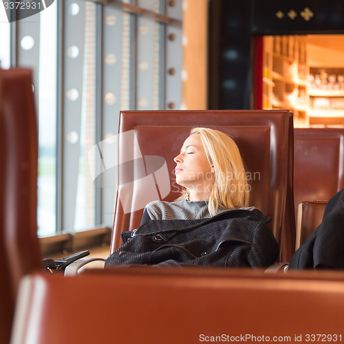 Image of Tired female traveler waiting for departure.