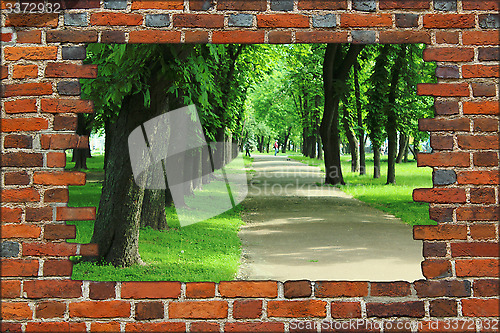 Image of broken brick wall and view to Summer park
