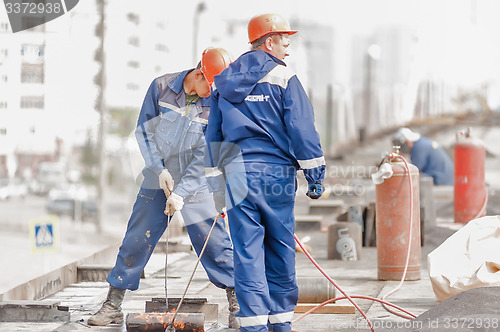 Image of Workers make waterproofing of seams on the bridge