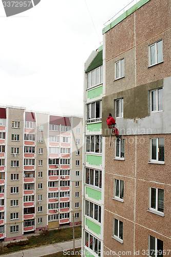 Image of specialist carring out warming of building's wall