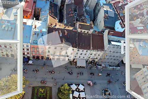 Image of opened window to the roofs of city