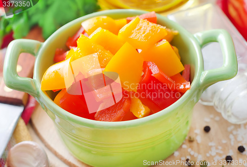 Image of red and yellow peppers on wooden background
