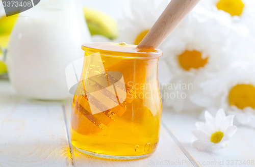 Image of fresh honey in the glass bank and milk in jug