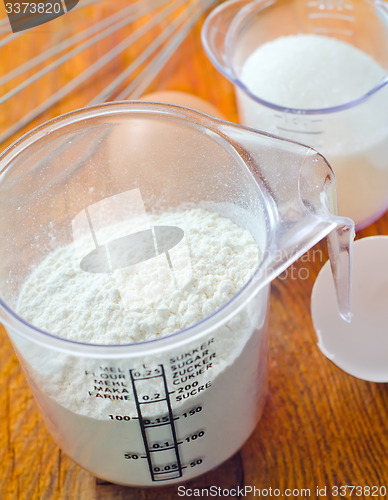 Image of Sugar, flour and raw eggs on the wooden board