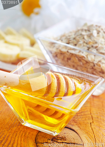 Image of Honey in the glass bowl on the wooden table