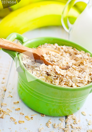 Image of Oat flakes in the green bowl with banana and milk