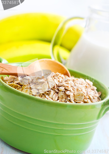 Image of Oat flakes in the green bowl with banana and milk