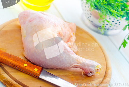 Image of Raw chicken and knife on the wooden board