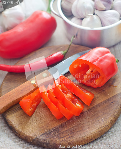 Image of Raw red peppers on the wooden board