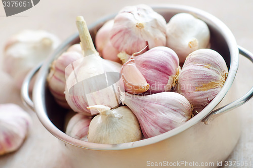 Image of garlic in metal bowl on the table