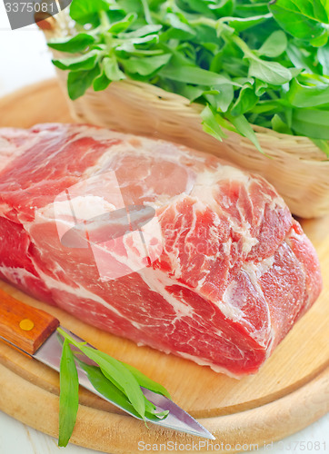 Image of raw meat and knife on the wooden board