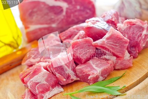 Image of raw meat and knife on the wooden board