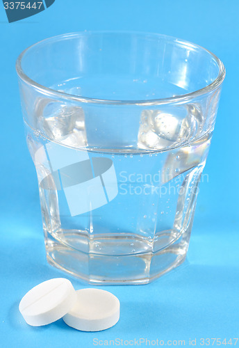 Image of white pills and water