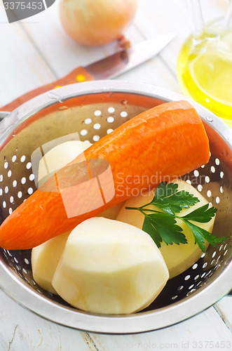 Image of Raw potato and carrot in the metal bowl