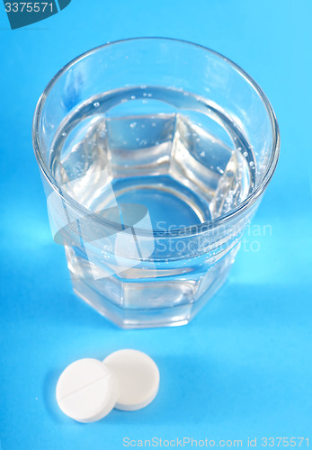 Image of white pills and water