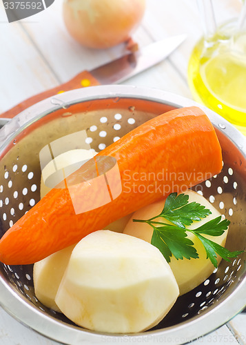 Image of Raw potato and carrot in the metal bowl