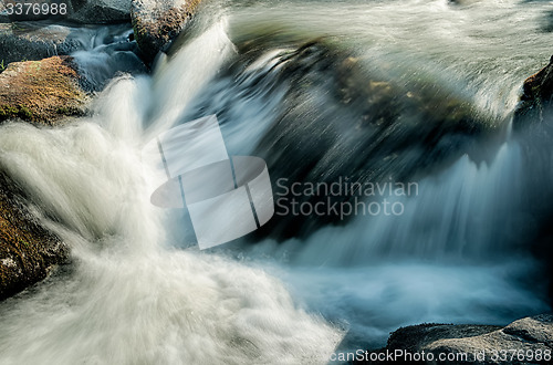 Image of broad river flowing through wooded forest