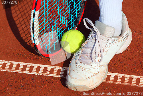 Image of Legs of man near the tennis racquet and balls