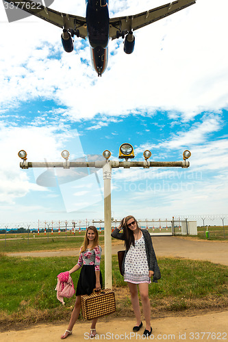 Image of Two girls hitchhiking a plane