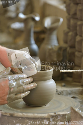 Image of hands making clay pot