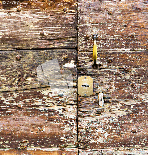 Image of castellanza   knocker in a  door curch  closed    cross