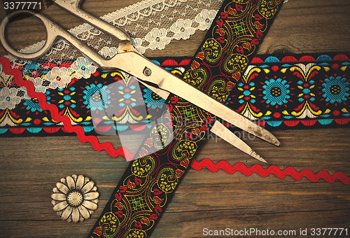 Image of old scissors, antique ribbons and flower button
