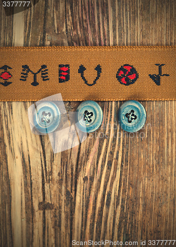 Image of vintage tape with embroidered ornaments and old buttons