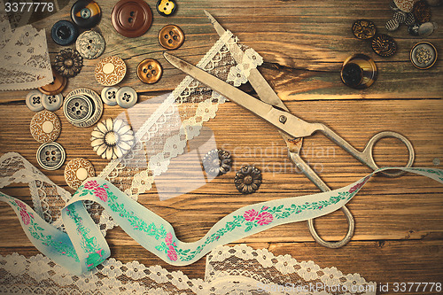Image of aged lace, vintage buttons and a dressmaker scissors