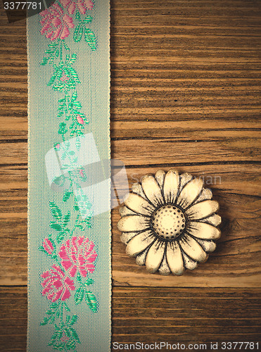 Image of vintage aqua color tape with embroidered ornaments and old butto