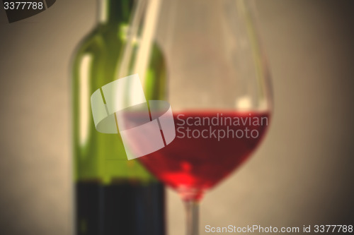 Image of red wine in goblets and green bottle