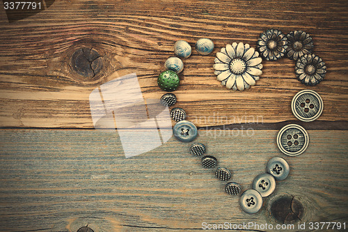 Image of vintage buttons heart on old textured boards