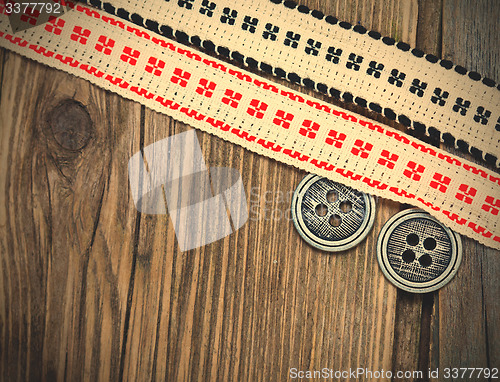 Image of two vintage ribbons with embroidered ornaments and old buttons