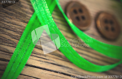 Image of still life with old green tape and two vintage buttons