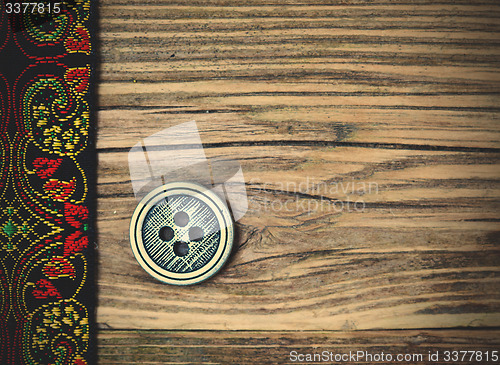 Image of old band with embroidered ornaments and vintage button