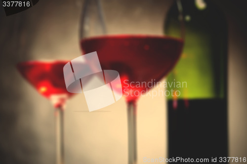 Image of red wine in two goblets and bottle