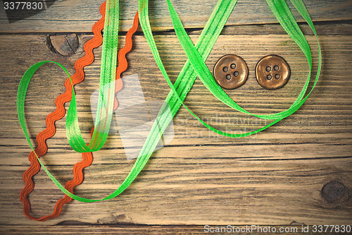 Image of still life with old green and red tapes and two vintage buttons