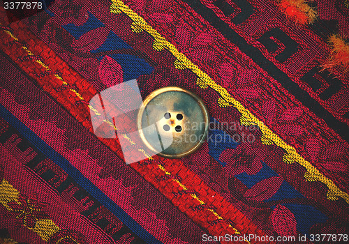 Image of vintage tape with embroidered ornaments and old brown buttons