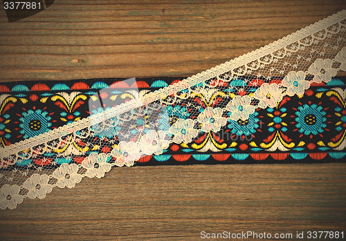 Image of vintage ribbons and lace on the aged boards