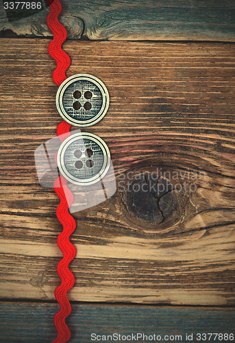 Image of vintage red tape and two old classic buttons