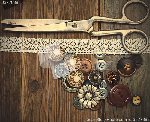 Image of antique buttons, lace and a tailor scissors