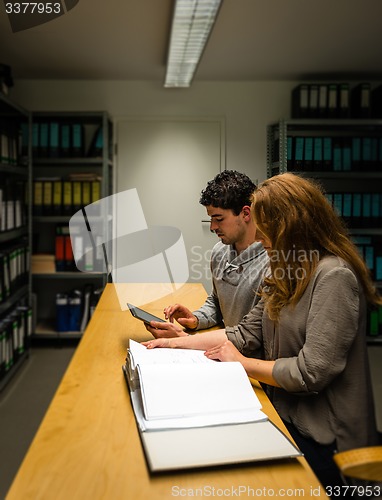 Image of digitalization: young man and woman in the company archives