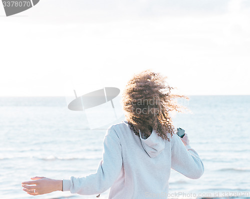 Image of energetic female moving by the ocean