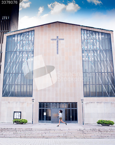 Image of female running in front of church