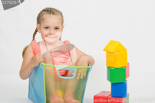 Image of The girl climbed into a box for toys
