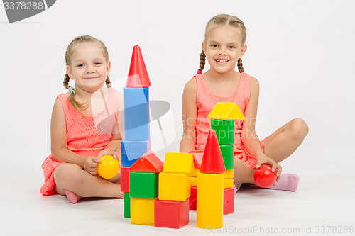 Image of Happy two girls built a castle out of blocks