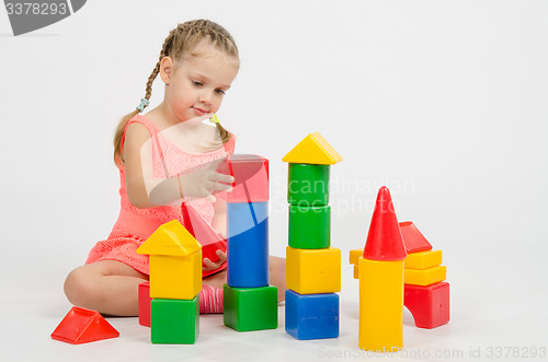 Image of Girl collects house of cubes