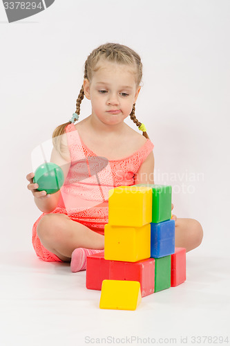 Image of The child does not know where to put ball in house