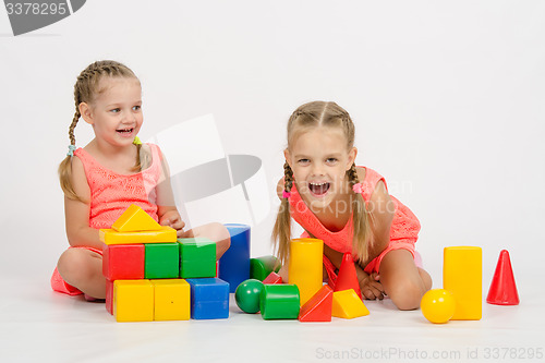 Image of Two girls laughing uncontrollably playing dice