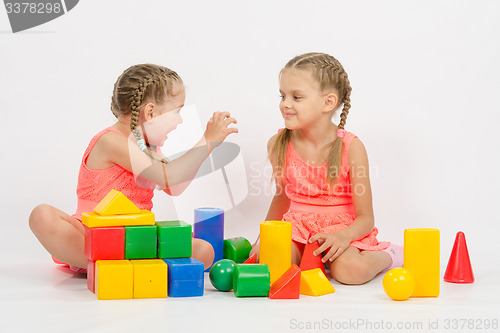 Image of Girl frighten another girl playing with blocks