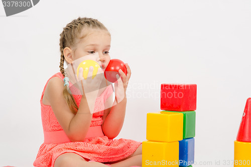 Image of Child being played in developing a set of put two balls to the cheeks